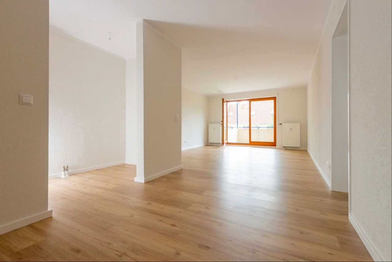 Fertig sanierter Wohnbereich mit hellen Wänden und durchgehendem Boden in Holzoptik